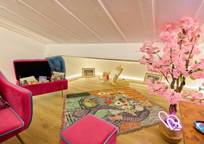 Alcôve artistique sous pente avec fauteuil et décoration inspirée du fauvisme dans la Chambre Matisse.