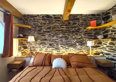 Lit double avec éclairage indirect et étagères décoratives dans la suite Calypso