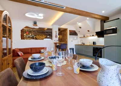 Pièce de vie de la suite Calypso avec cuisine équipée moderne et table à manger dressée
