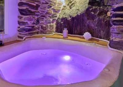 Espace spa Calypso avec baignoire balnéo sous arche en pierre