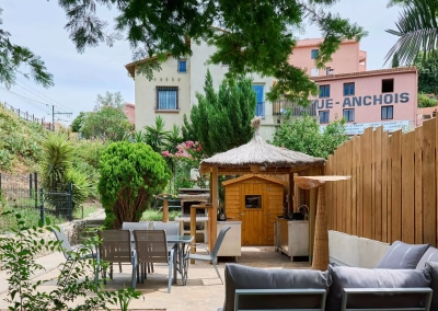 Coin détente avec table et chaises au fond du jardin.