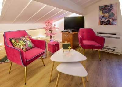 Espace salon avec fauteuils roses et ambiance artistique dans la Chambre Matisse à Collioure.