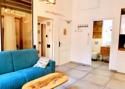 Salon lumineux avec canapé bleu dans la suite Le Ginkgo à Collioure