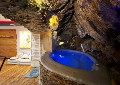 Jacuzzi intégré dans la roche avec éclairage bleu – Le Ginkgo