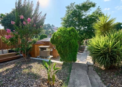 Jardin arboré menant au cabanon du jacuzzi.