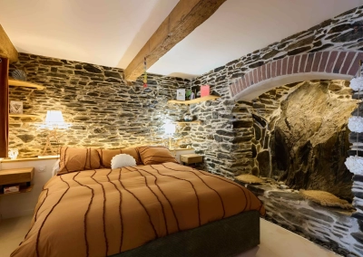 Chambre avec mur en pierre et éclairage tamisé – Le Calypso à Collioure