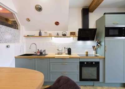 Cuisine équipée avec plan de travail en bois et crédence blanche dans le logement Le Calypso à Collioure.