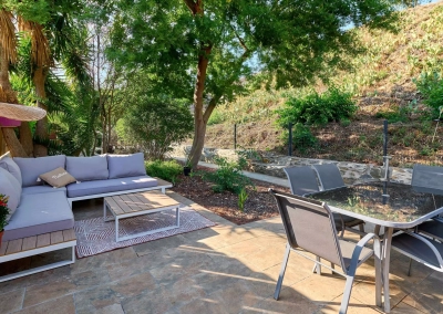 Salon de jardin avec canapé et table basse sur terrasse.