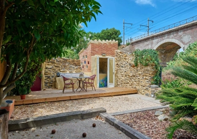 Terrasse extérieure avec vue sur pont ferroviaire en arrière-plan.